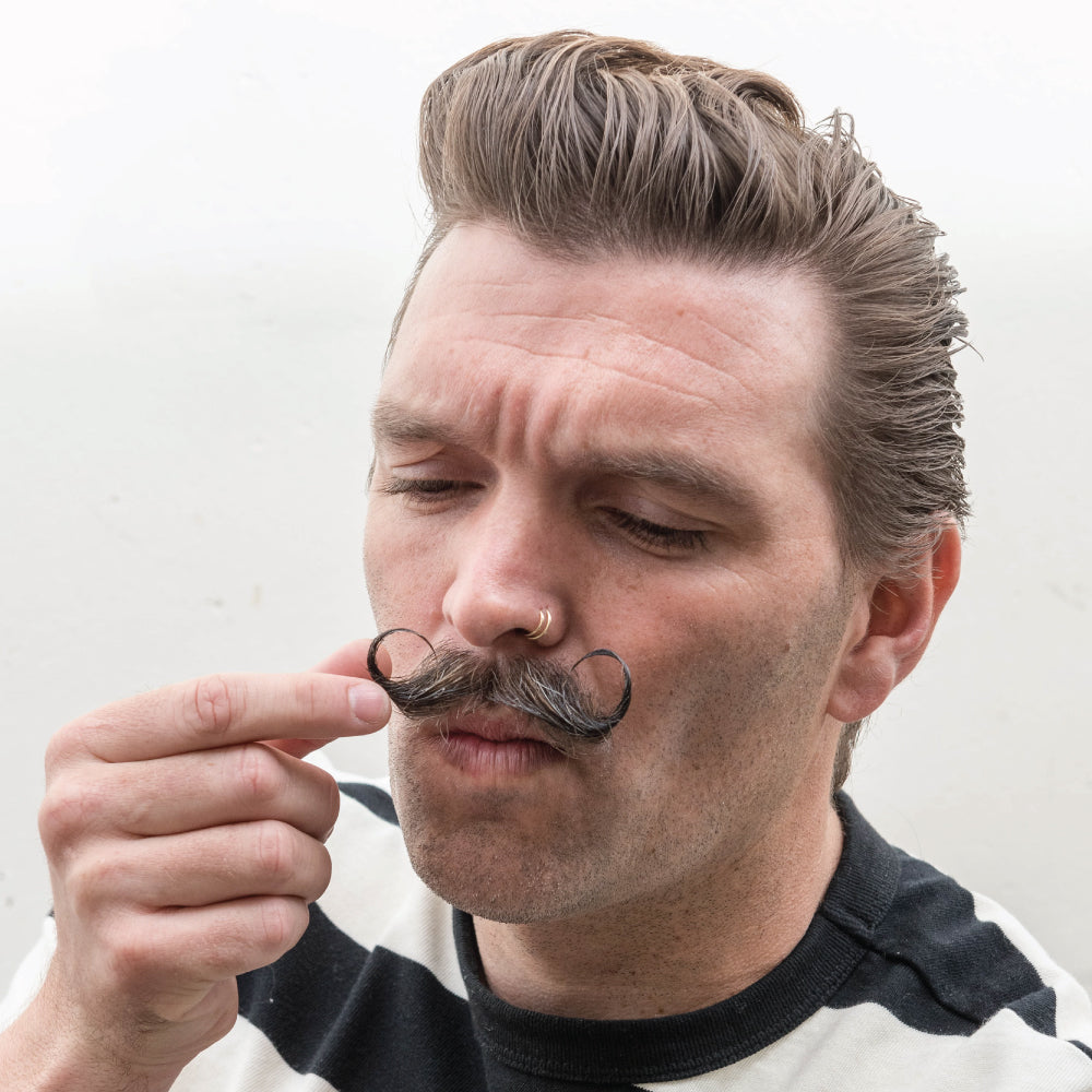 Model applying mega wax and curling mustache 