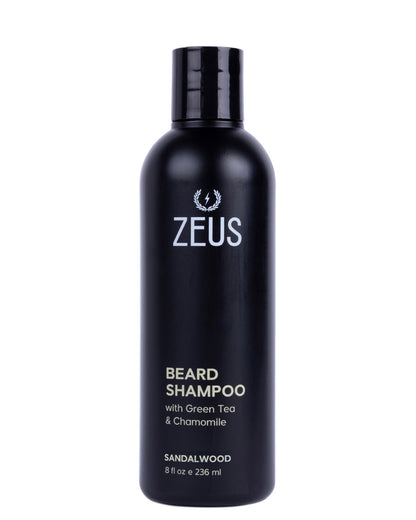 A black bottle of Zeus Beard Shampoo with green tea and chamomile, sandalwood scent, on a plain white background.