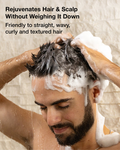 Man washing his hair with a shower curtain in the background